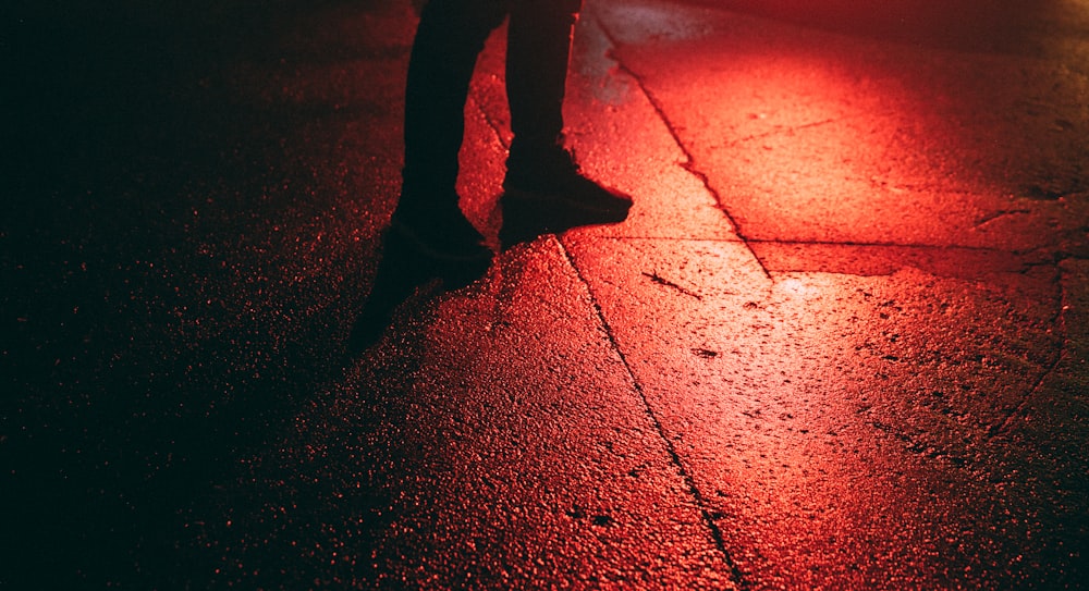 una persona in piedi su una strada di notte