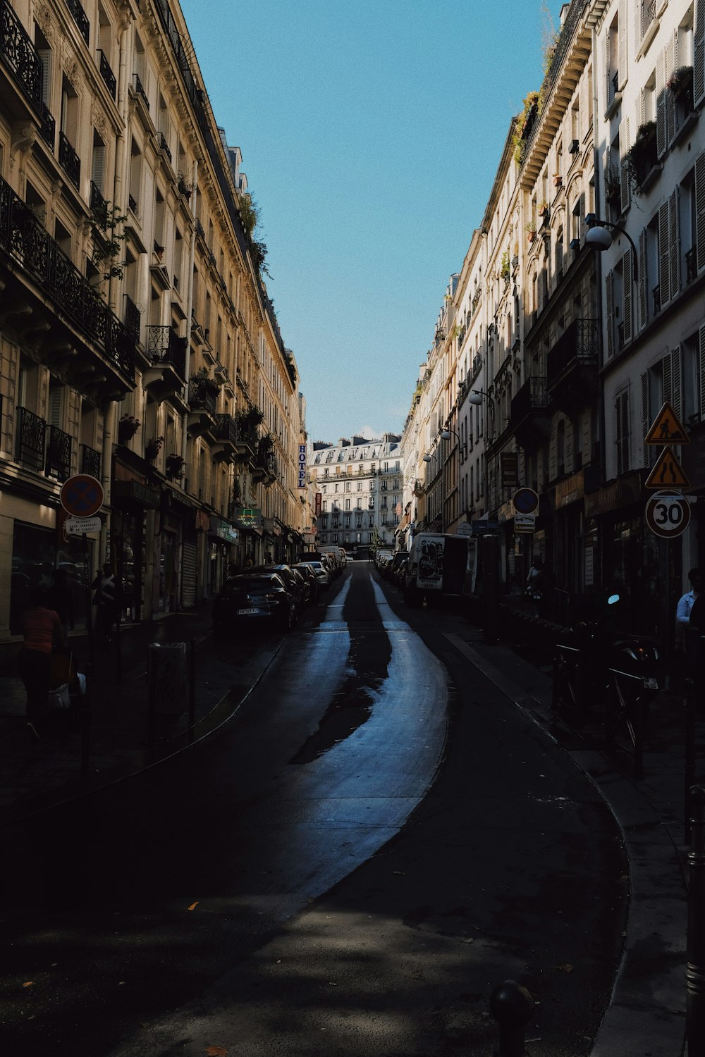 gray concrete road between buildings at daytime