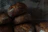 Close-up of freshly baked rustic bread loaves stacked on a wooden counter.
