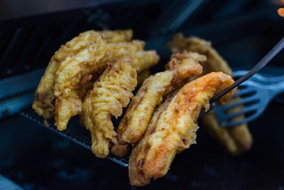 Close-up of golden brown fish meal granules in a wooden bowl on a marine-themed background.