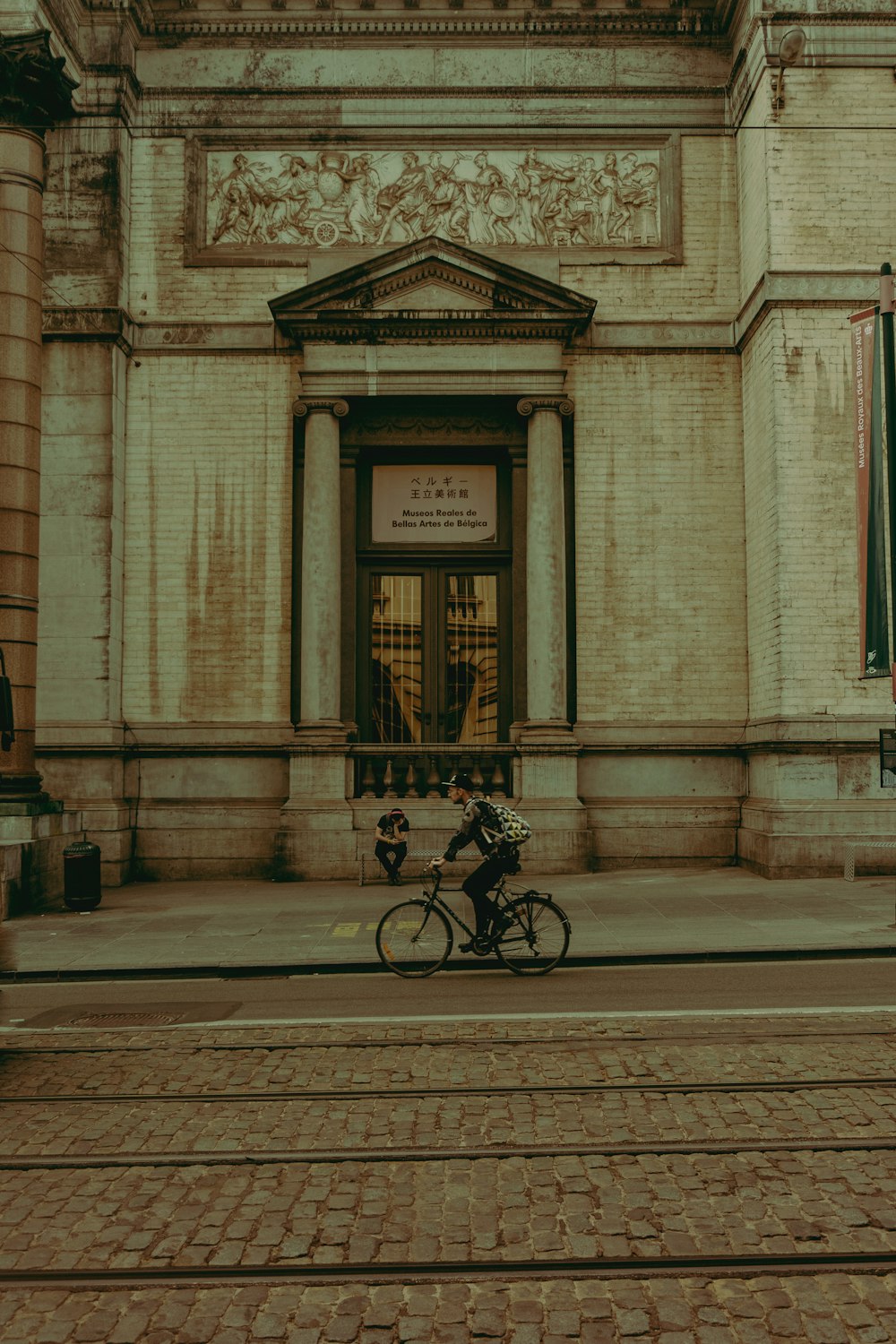 man riding bicycle front of building