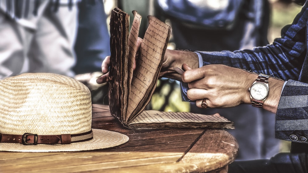 Persona que sostiene el libro abierto