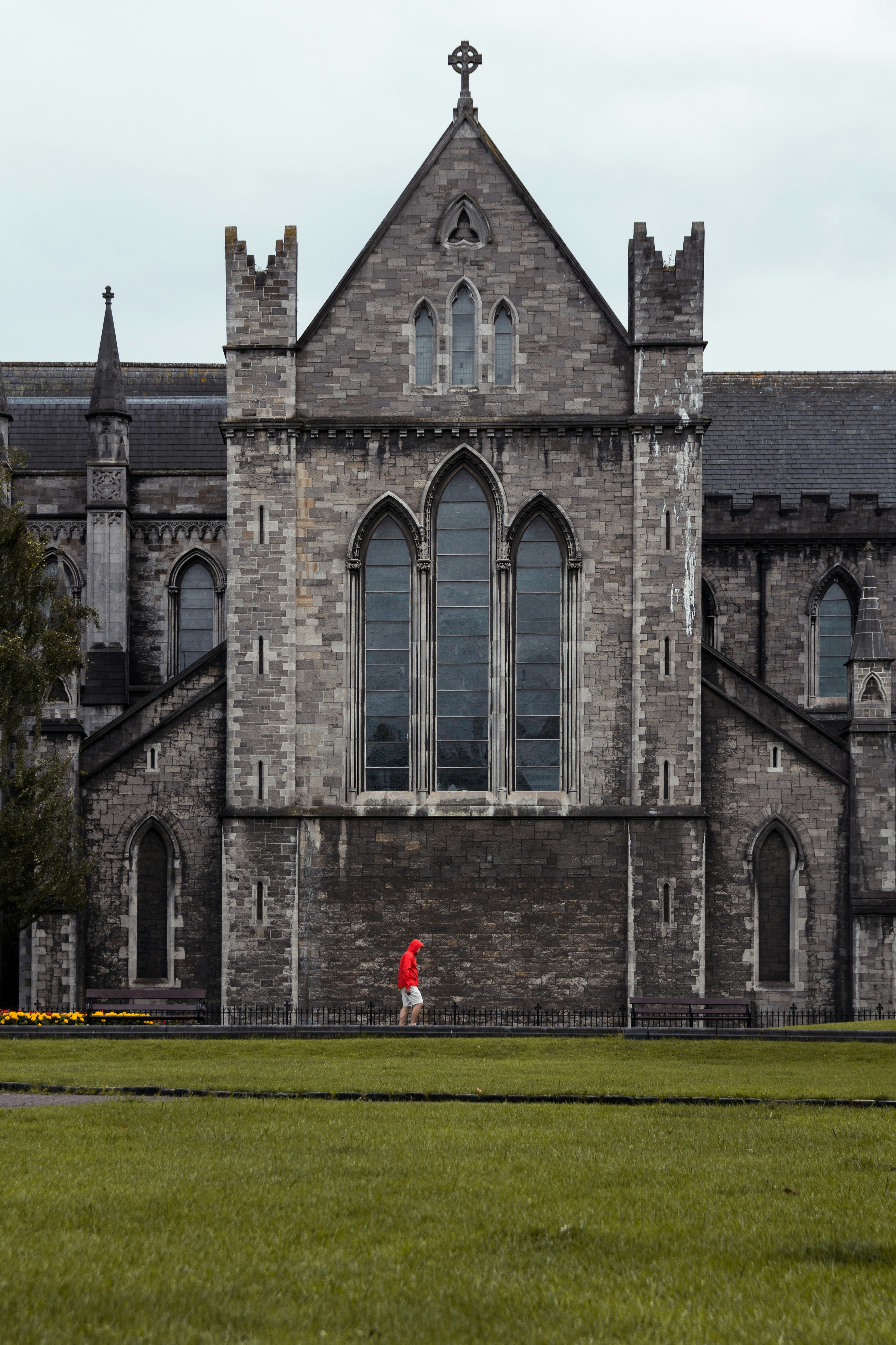 person walking outside gray concrete mansion