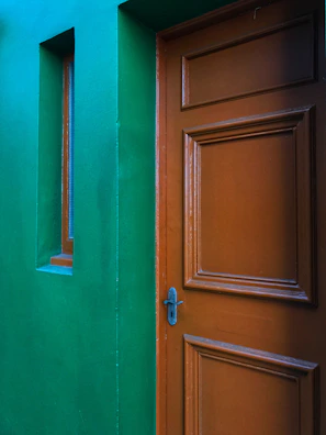 Classic paneled door painted in a rich, warm color at a residential entrance.