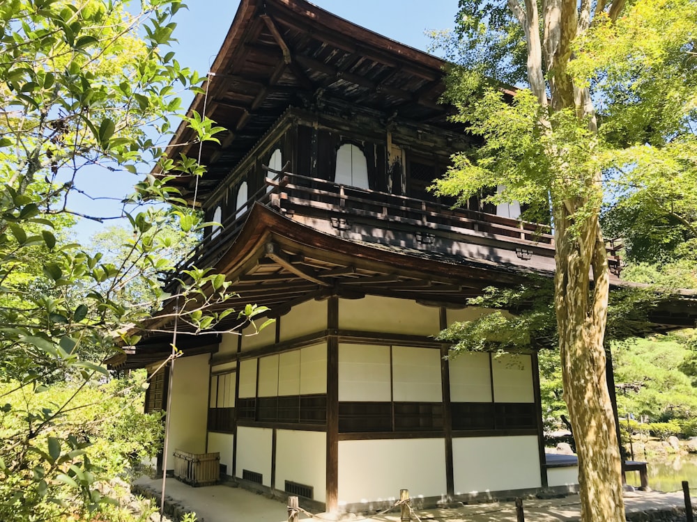 木々に囲まれた茶色と白の木造住宅