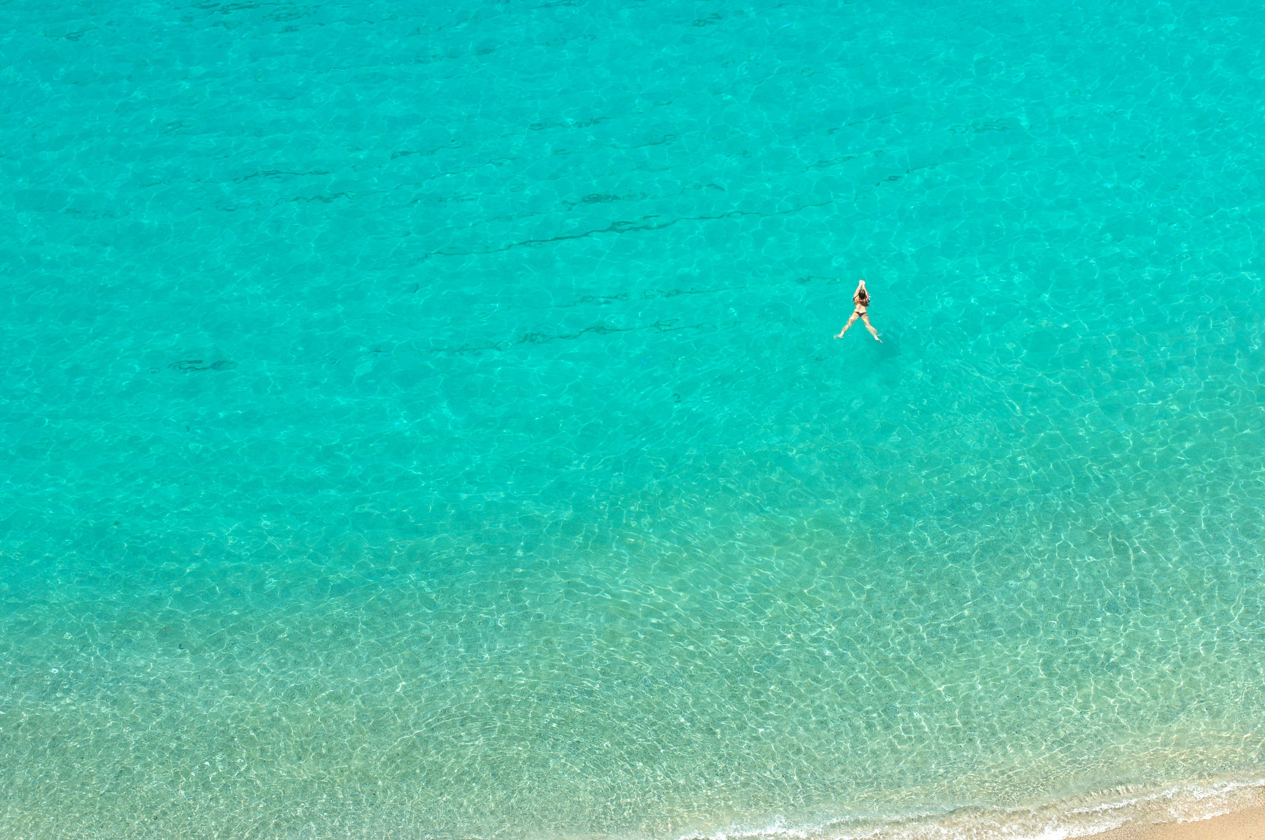 person on shore, A refreshing swim in the turquoise sea of Calabria. 
