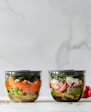 four clear plastic bowls with vegetables