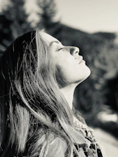 Soft focus image of a peaceful woman breathing deeply in nature.
