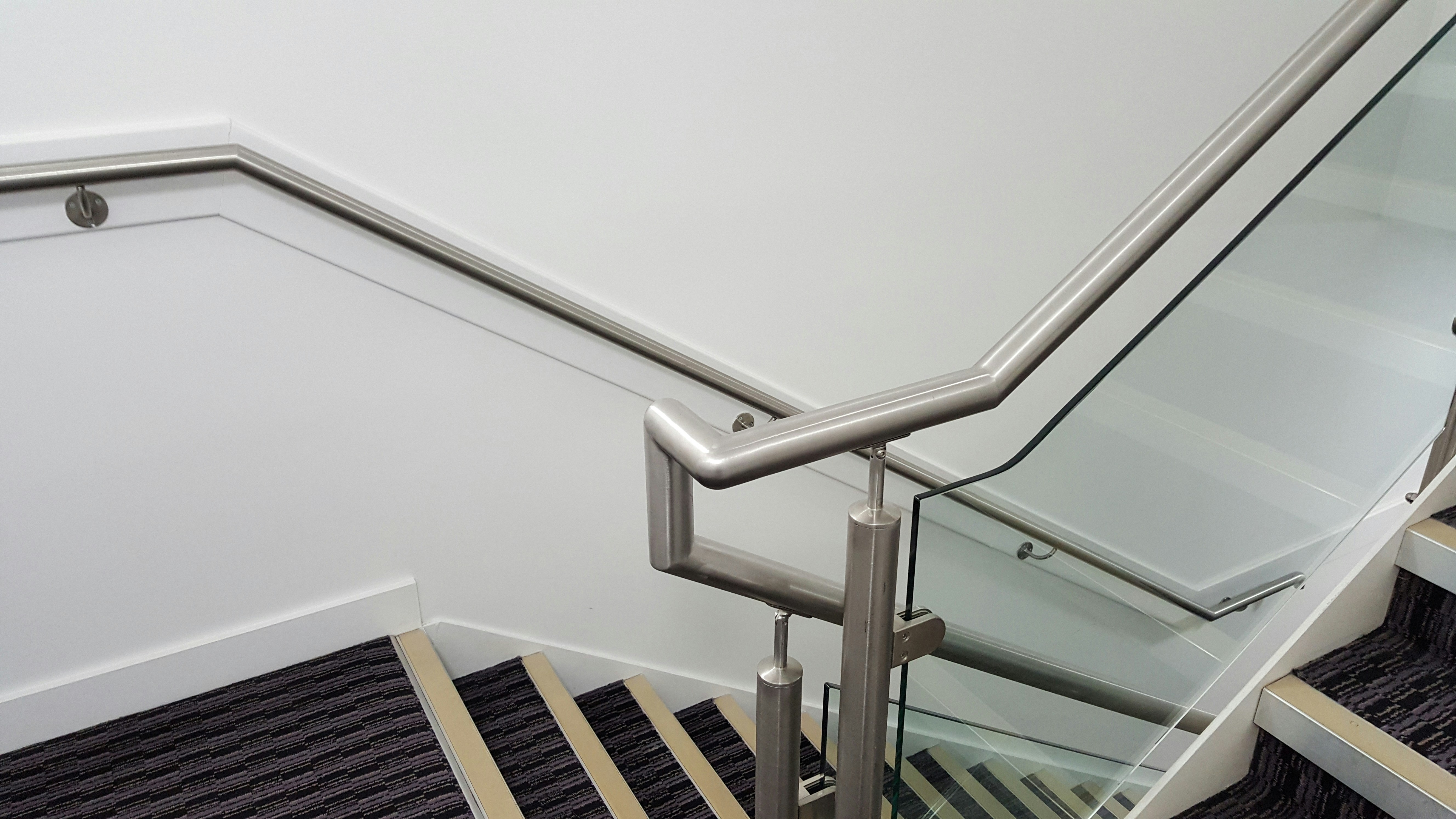 Frameless glass balustrade on modern staircase with oak handrail