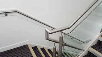 A modern staircase featuring sleek stainless steel handrails and clean lines.