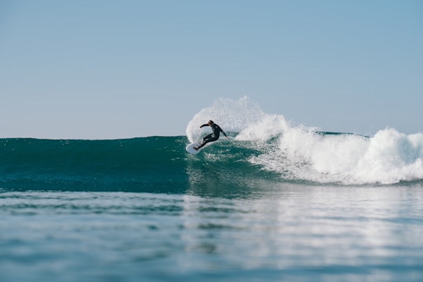 Close-up of a surfboard cutting through the ocean spray during a dynamic ride.