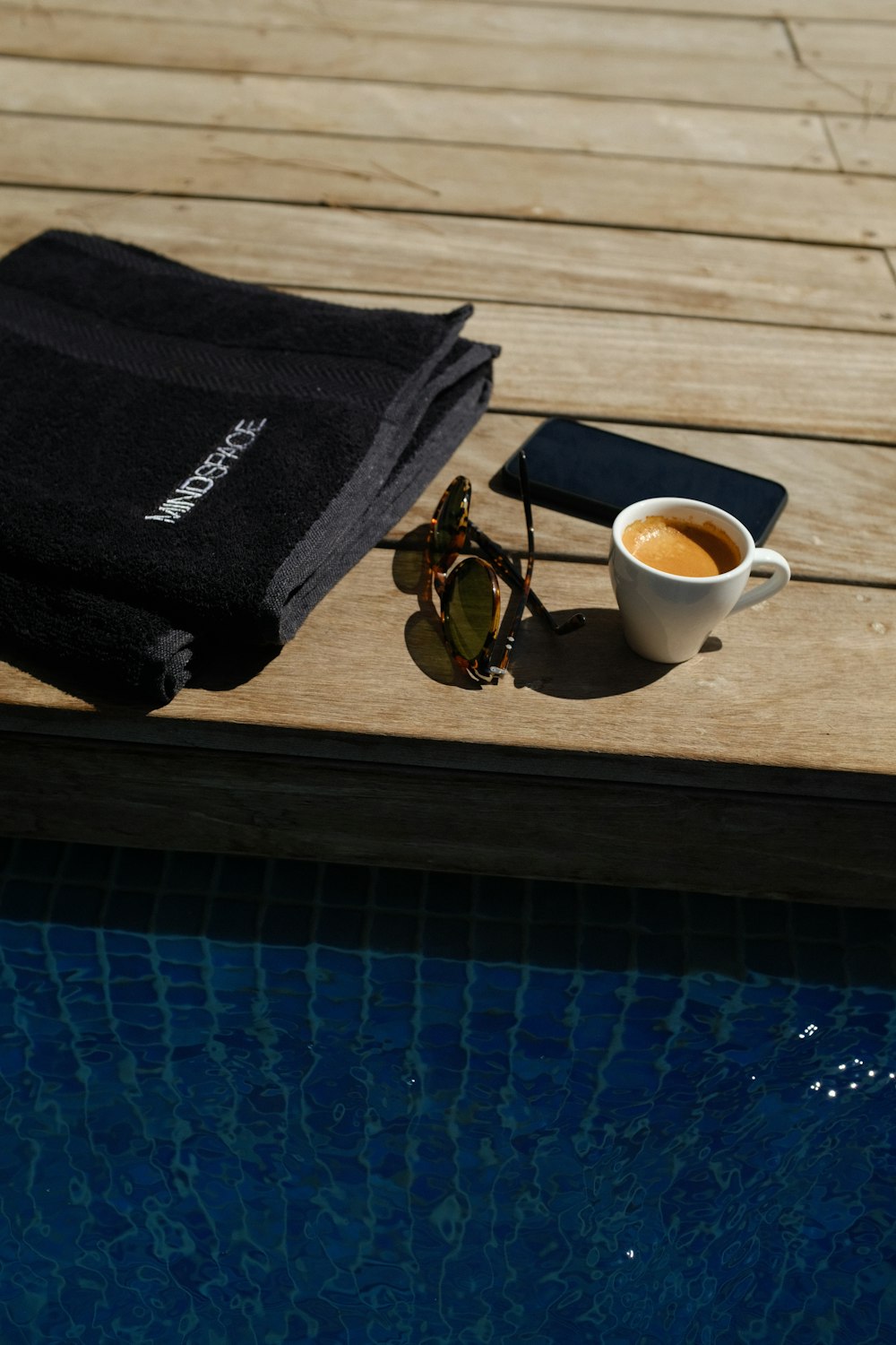 coffee filled mug beside sunglasses