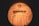 A close-up view of a ball with the logo 'Spikeball' visible on its surface. The ball appears to be illuminated with a warm, yellow-orange glow, accentuating its texture and design.