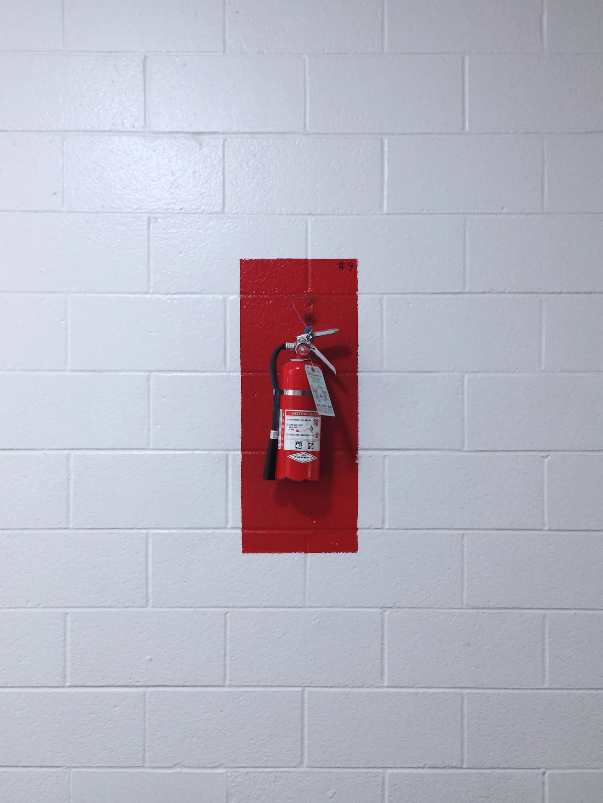 Brandblusser aan een witte muur in een bedrijfspand