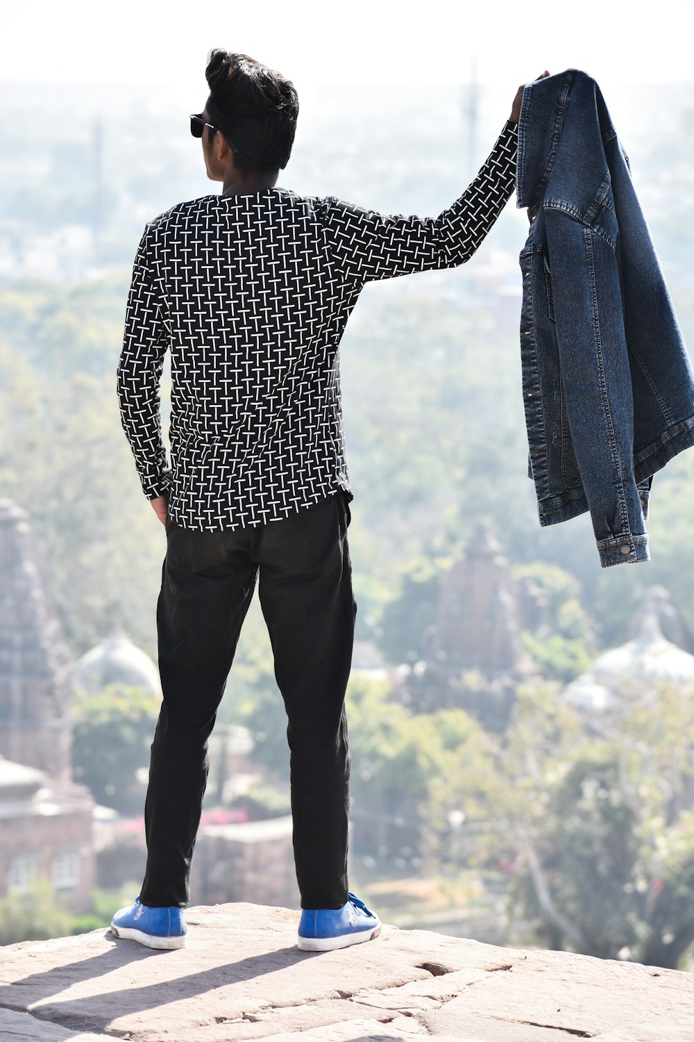 man holding blue denim jacket