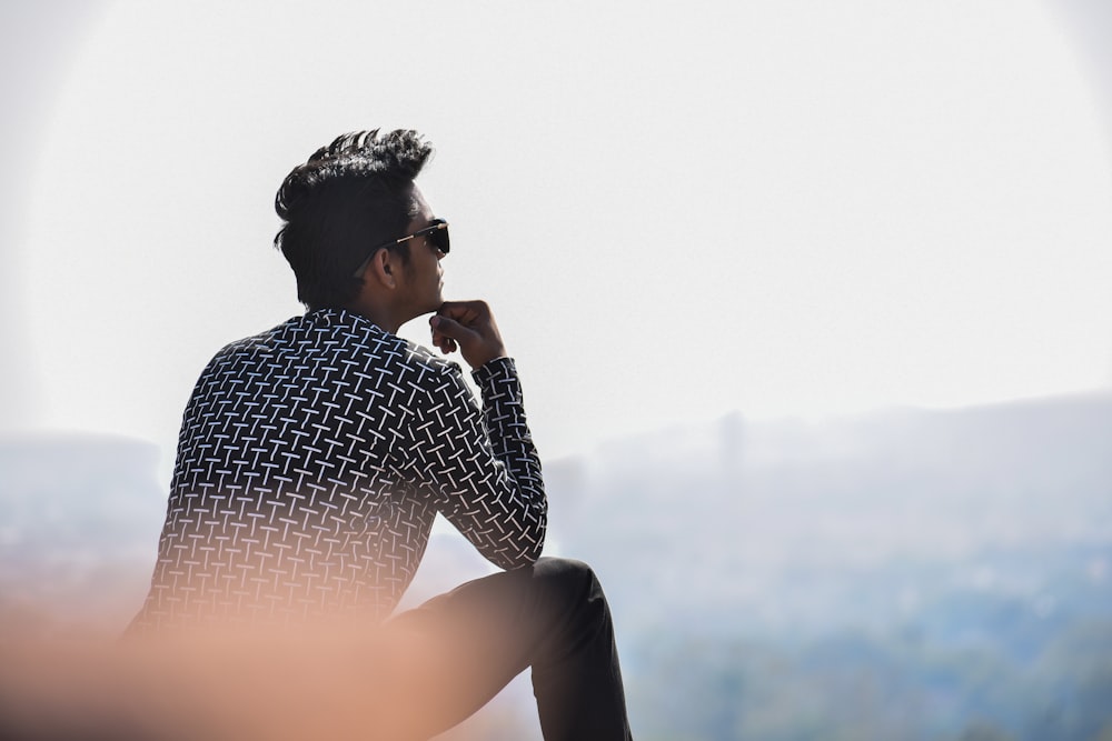 man sitting front of mountain at daytime