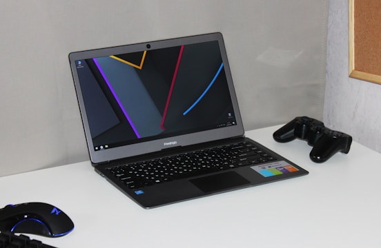 A sleek laptop and desktop setup side by side on a modern desk.