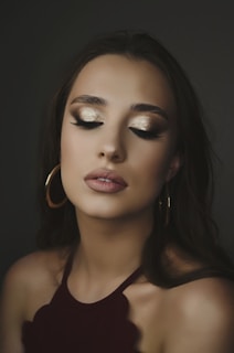 Young woman applying rose gold eyeshadow in soft natural light