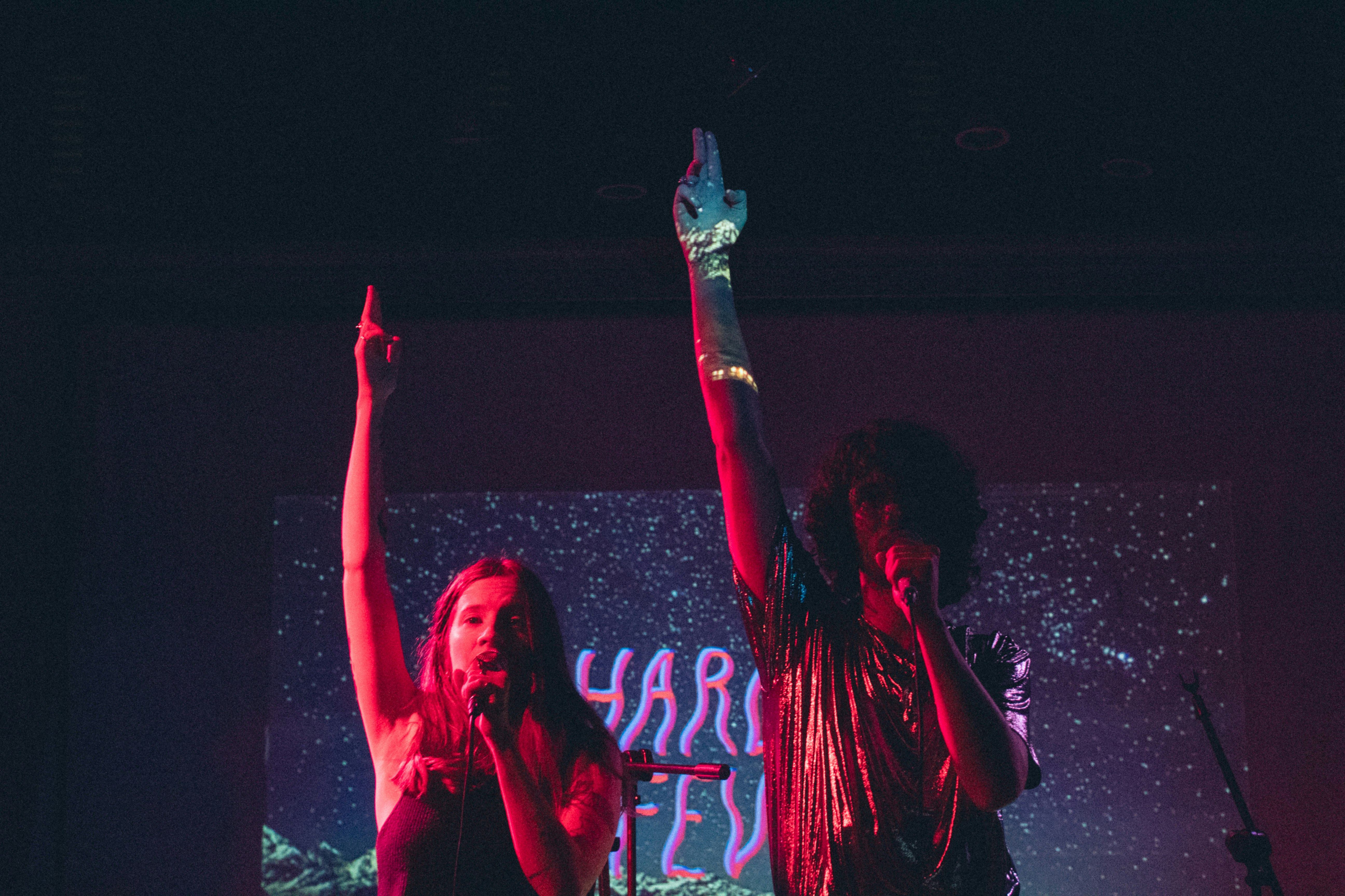 two persons raising hands