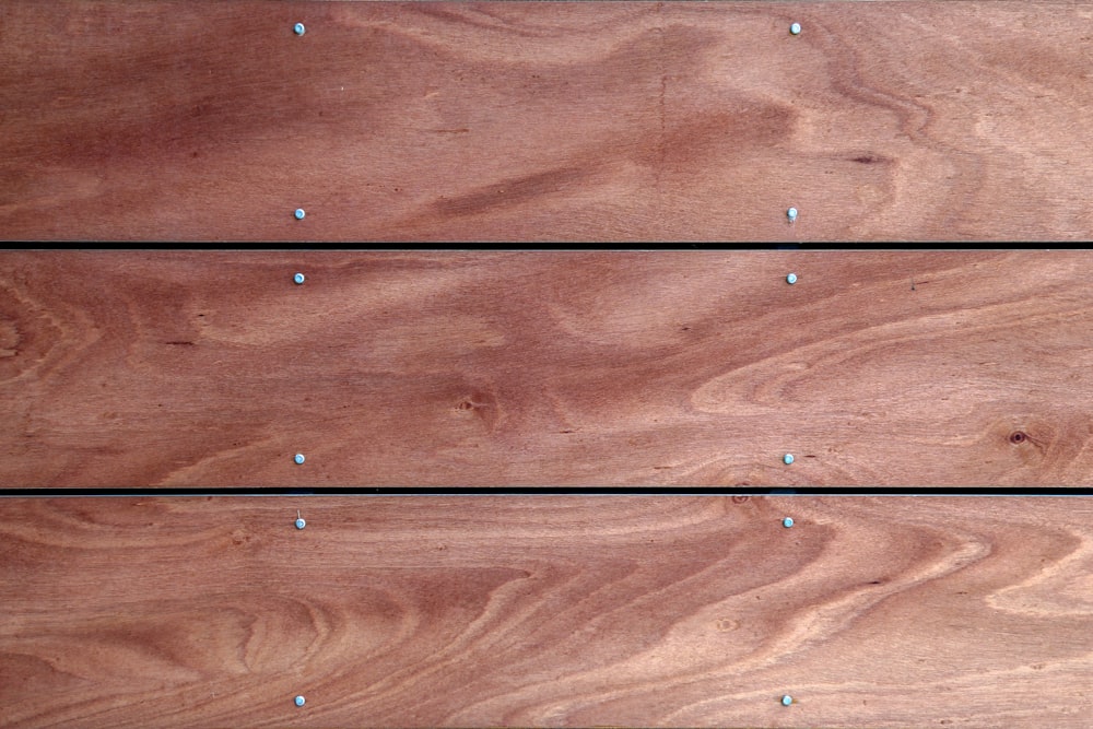a close up of a piece of wood with rivets