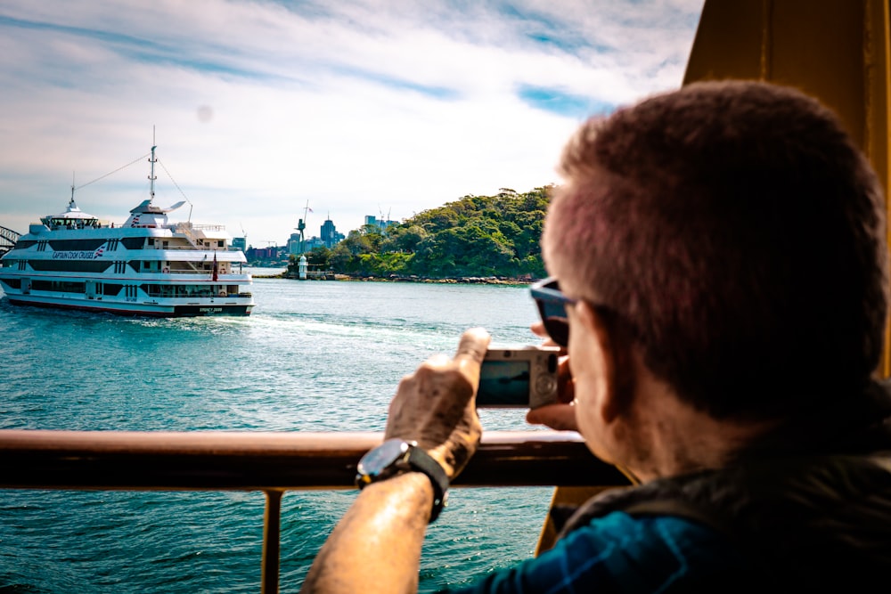 man taking picture of cruiser ship