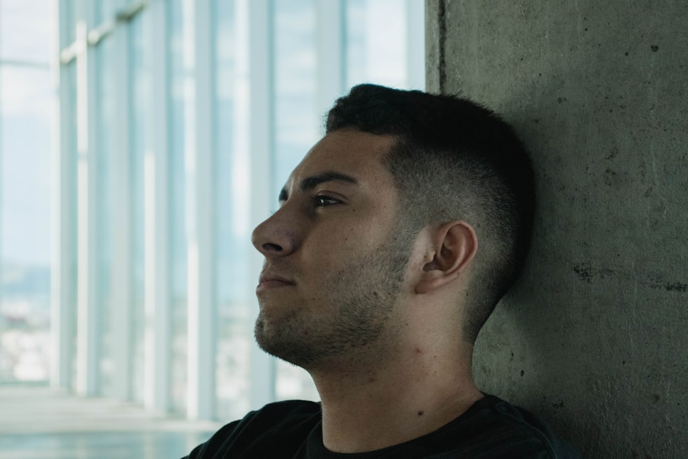 man leaning on concrete wall