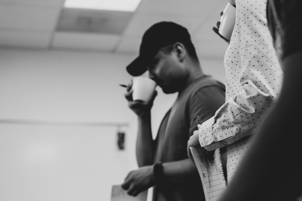 Una foto in bianco e nero di un uomo che tiene in mano una tazza di caffè