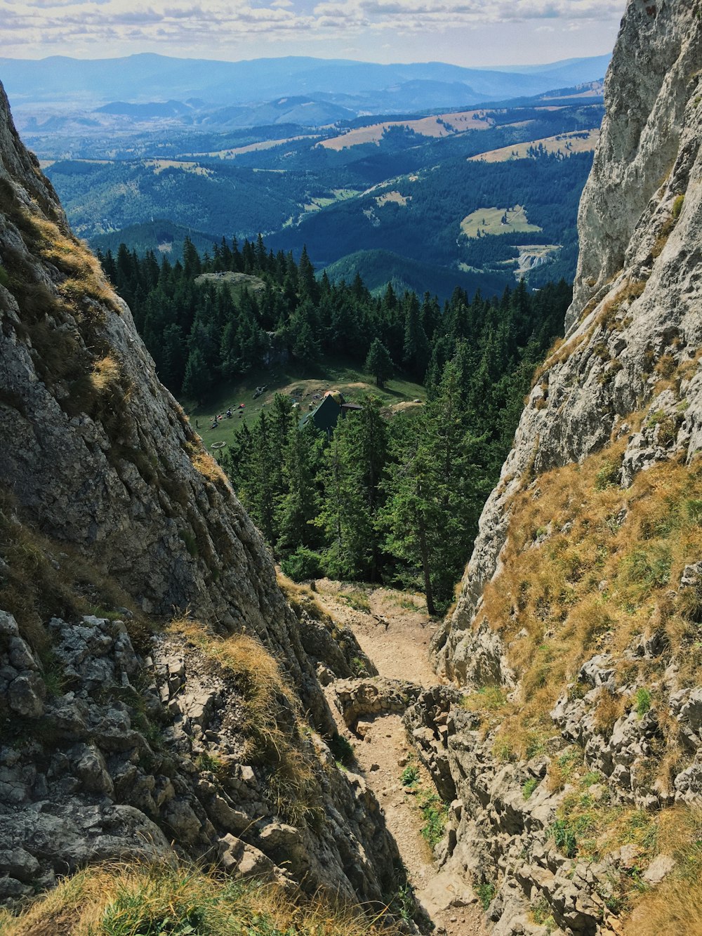 aerial photography of green field viewing mountain under white and blue skies during daytime