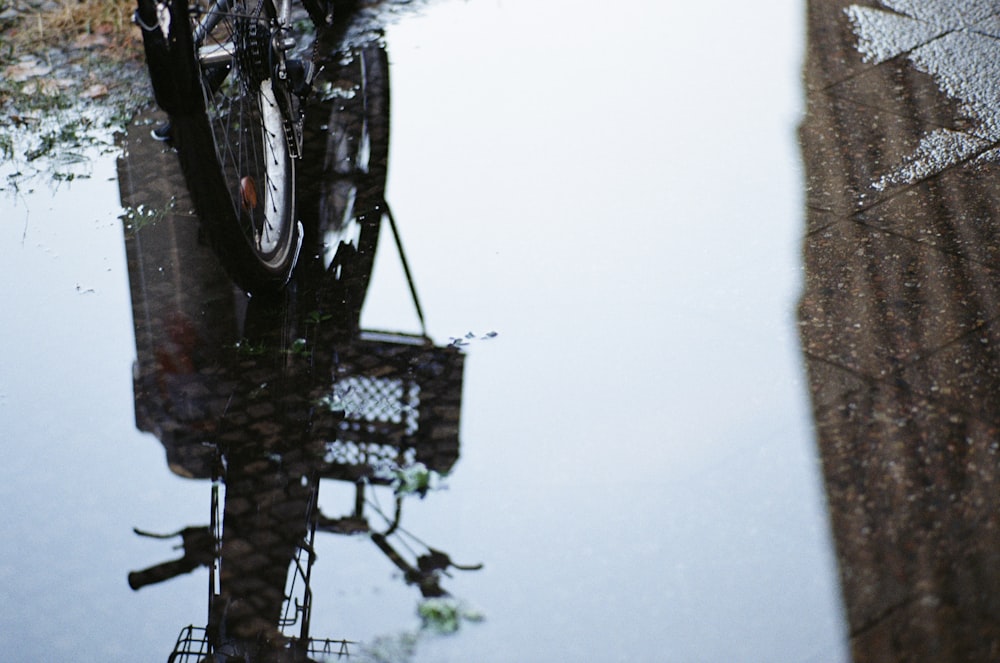 black bicycle on the road with water