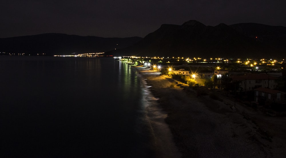 a night time view of a beach with lights on