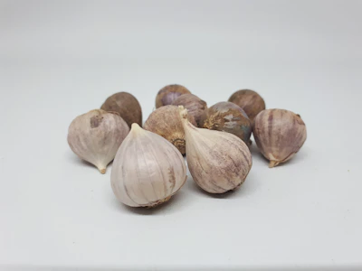 Fresh white garlic bulbs with papery skins resting on burlap.
