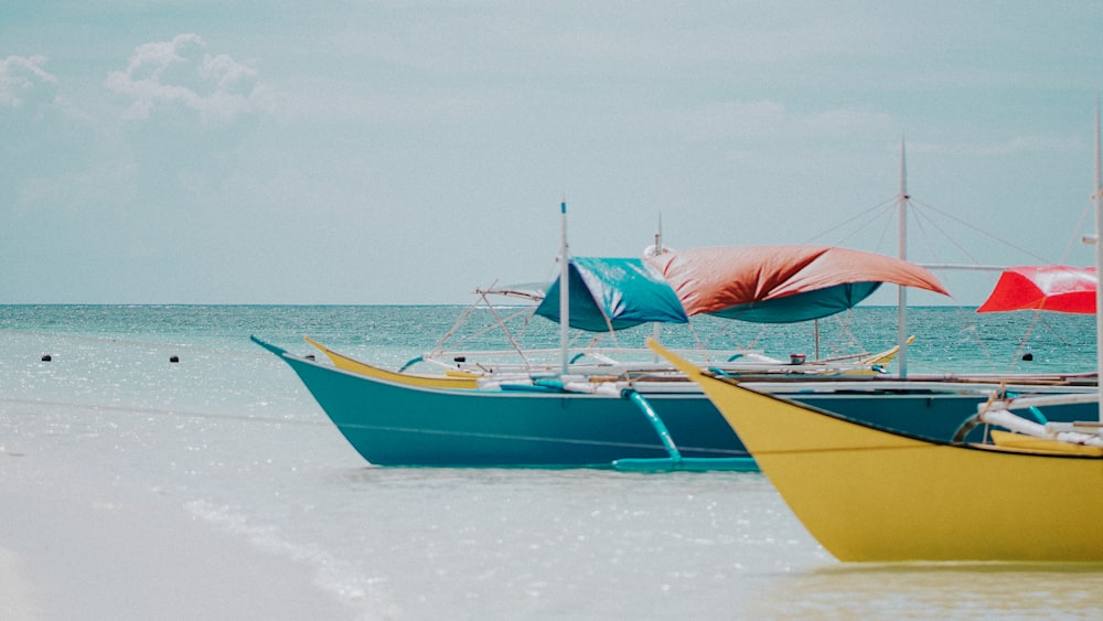 green and yellow boats on sea under blue and white skies during daytime