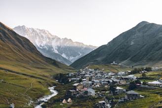 aerial photography of houses beside rocky mountains during daytime