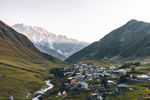 aerial photography of houses beside rocky mountains during daytime