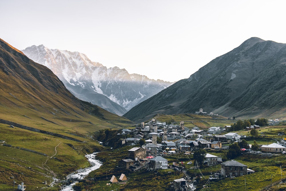 aerial photography of houses beside rocky mountains during daytime