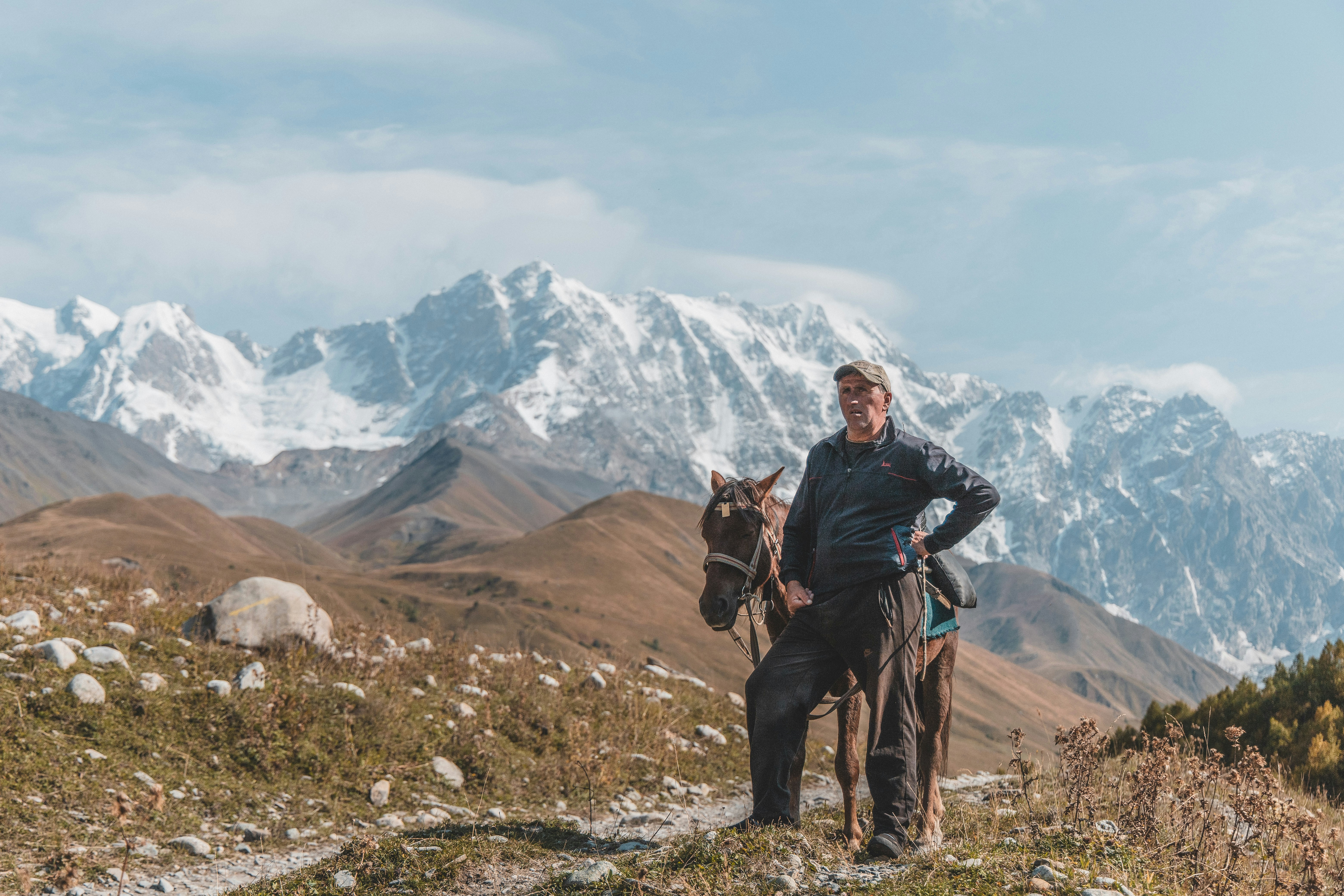 man standing beside horse during daytime