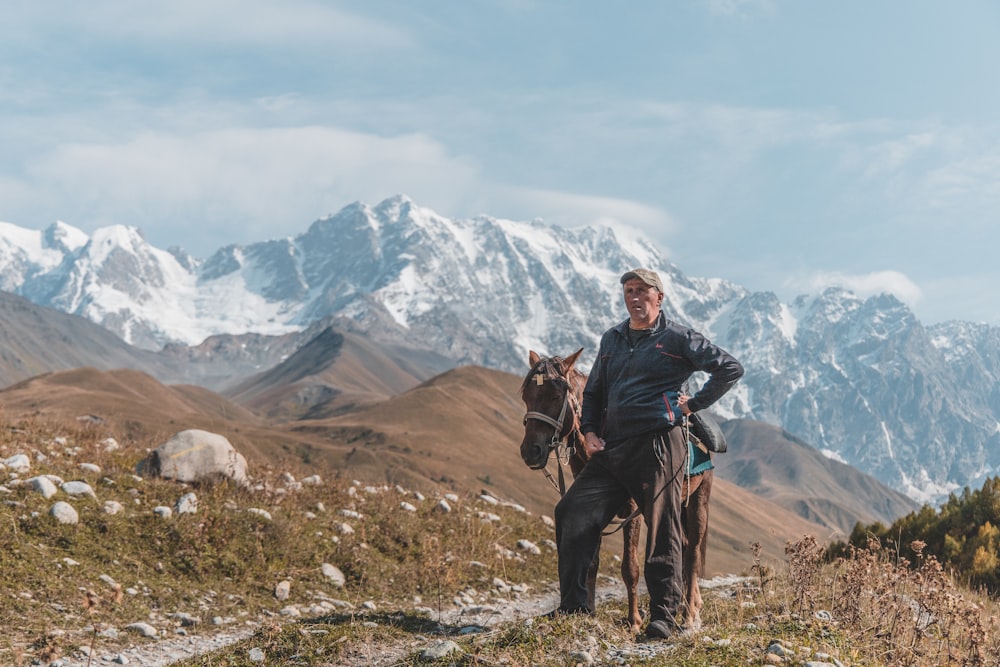 man standing beside horse during daytime