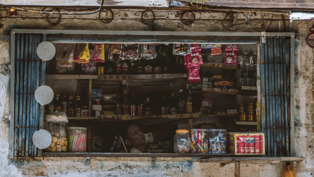 a store front with a man looking out the window