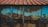 A weathered and rusted metal sheet is supported by vertical wooden beams, featuring a combination of blue paint and brown rust stains. The metal is topped with a corrugated roof of reddish-brown tin.