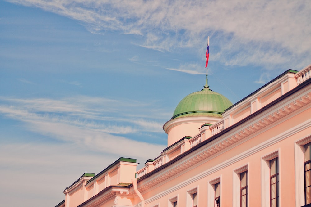 pink and green dome building under blue and white skies during daytime