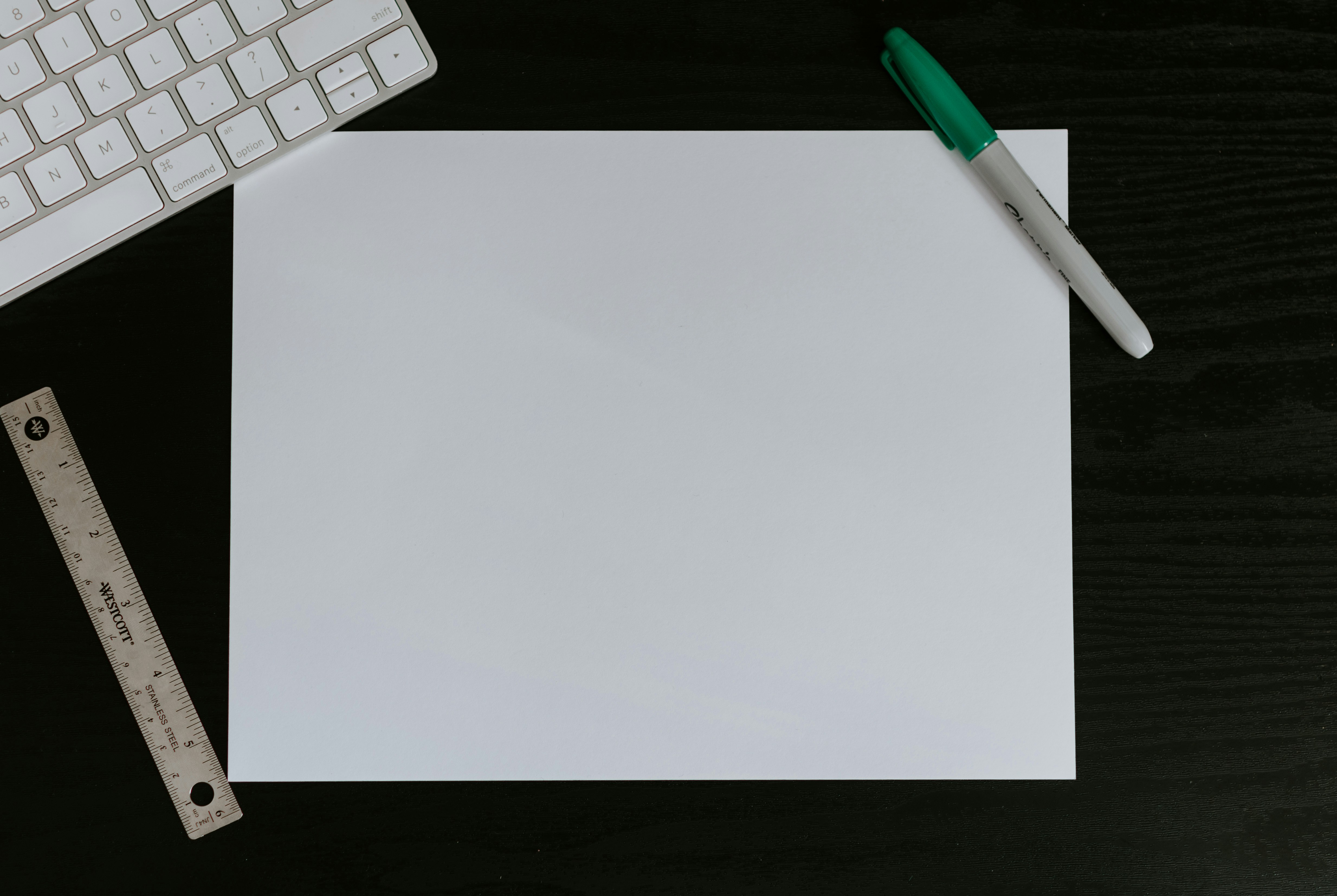 Blank piece of white paper on a black desk