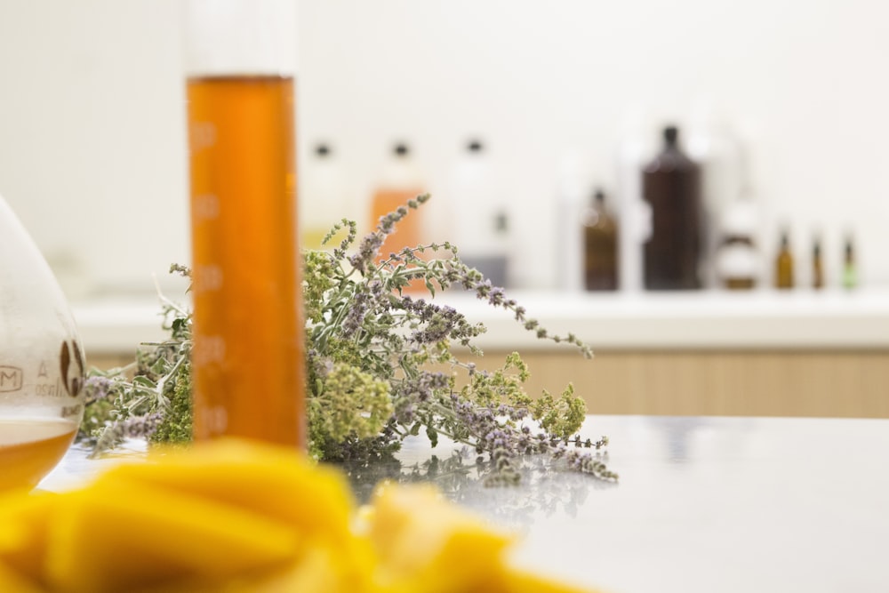 Una botella de líquido naranja encima de una mesa