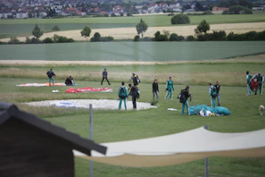 A group of excited skydivers gearing up on the tarmac, helmets and jumpsuits ready for the jump.