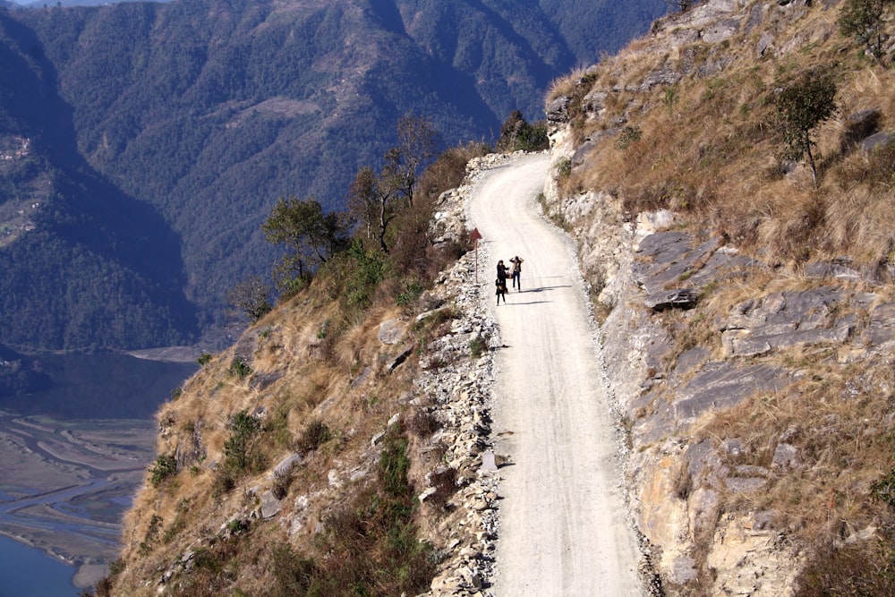 people on road on side of mountain