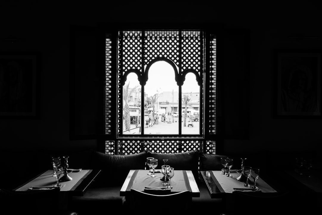 grayscale photo of table setting near window