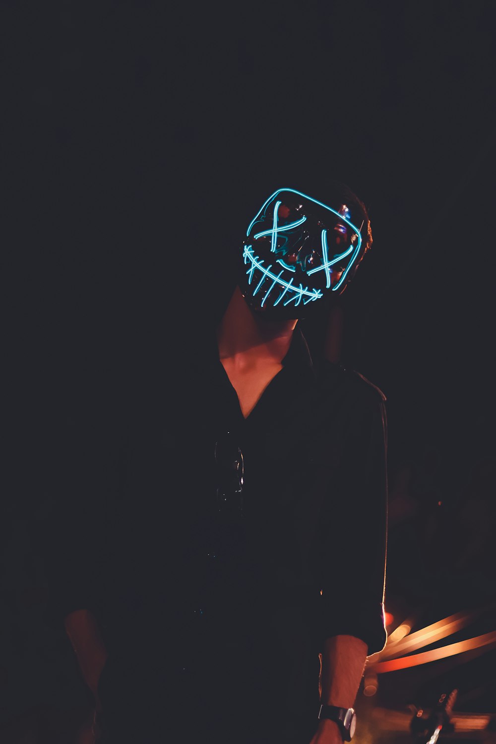 a man wearing a neon mask in the dark