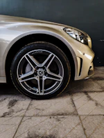Close-up of a premium car's copper metallic wheel with subtle reflections on a dark textured background.