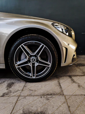 Close-up of a premium car's copper metallic wheel with subtle reflections on a dark textured background.