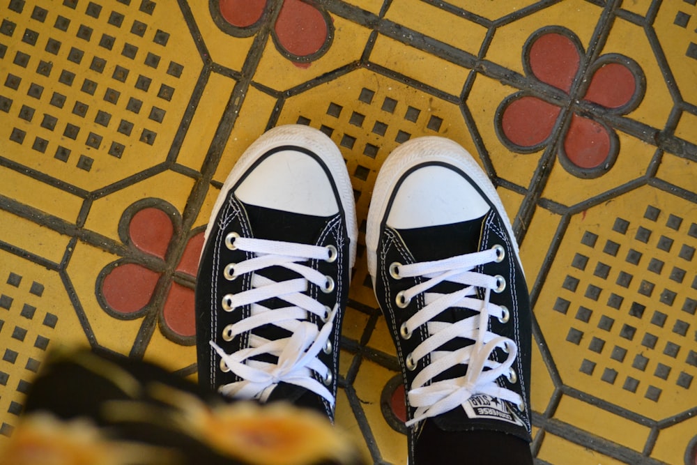 person in black-and-white Converse AllStar sneakers
