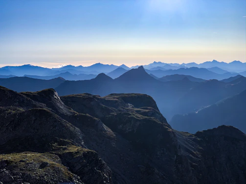 Wide panoramic view of rugged mountain ridges stretching into the distance with soft morning light.